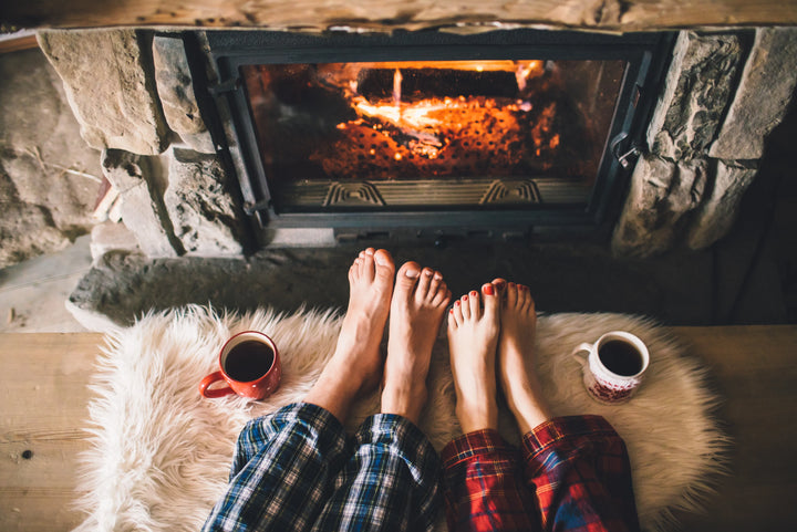 Couples feet warming in front of an open fire